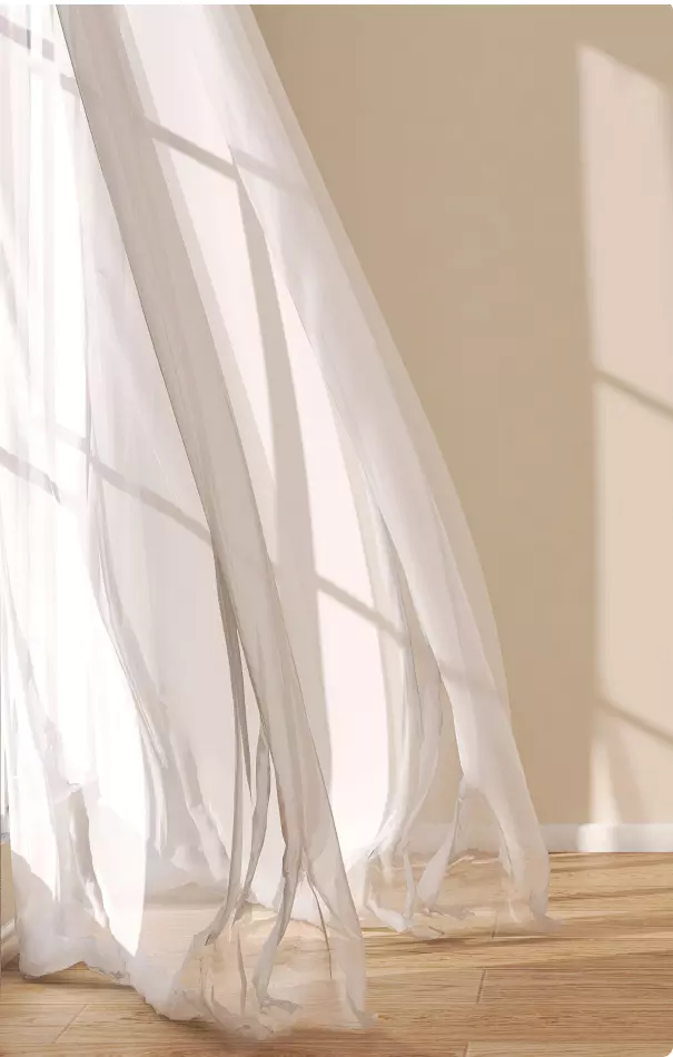 Drappeggio di una leggera tenda bianca che si muove delicatamente, con luci e ombre che si intrecciano.